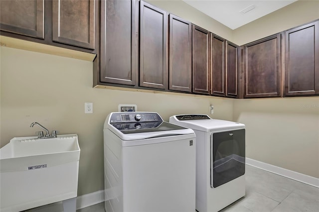 4155 Barletta Ct, Wesley Chapel, FL 33543 - laundry area with cabinet space, washing machine and clothes dryer, baseboards, and light tile patterned flooring