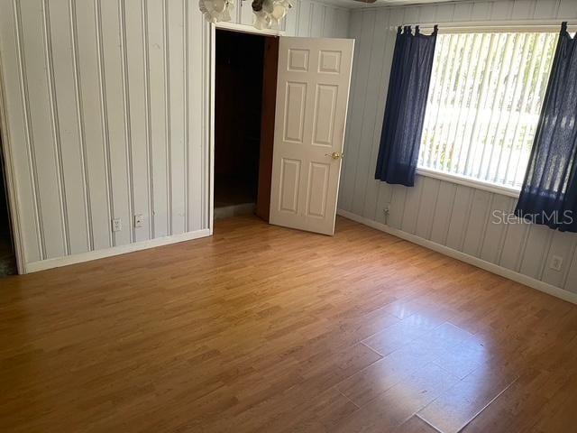15034 Lake Magdalene Blvd, Tampa, FL 33618 - unfurnished bedroom featuring wood finished floors, baseboards, and wood walls