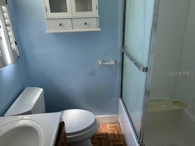 15034 Lake Magdalene Blvd, Tampa, FL 33618 - full bath featuring toilet, a shower with shower door, vanity, and baseboards