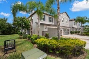 1395 White Fox Run, Lutz, FL 33549 - view of front of property with an attached garage, concrete driveway, stucco siding, and a front lawn