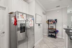 1395 White Fox Run, Lutz, FL 33549 - kitchen featuring stainless steel refrigerator with ice dispenser, ornamental molding, white cabinetry, baseboards, and light tile patterned flooring