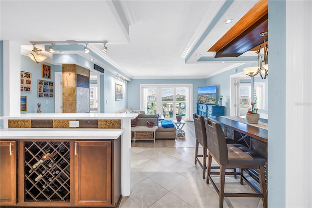 4900 Brittany Dr S Unit 611, Saint Petersburg, FL 33715 - kitchen with open floor plan, ornamental molding, light tile patterned flooring, track lighting, and brown cabinetry