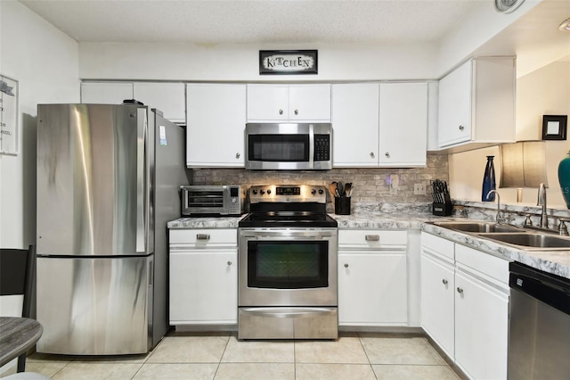 6630 Spring Flower Dr Unit 14, New Port Richey, FL 34653 - kitchen with stainless steel appliances, a sink, white cabinetry, backsplash, and light countertops