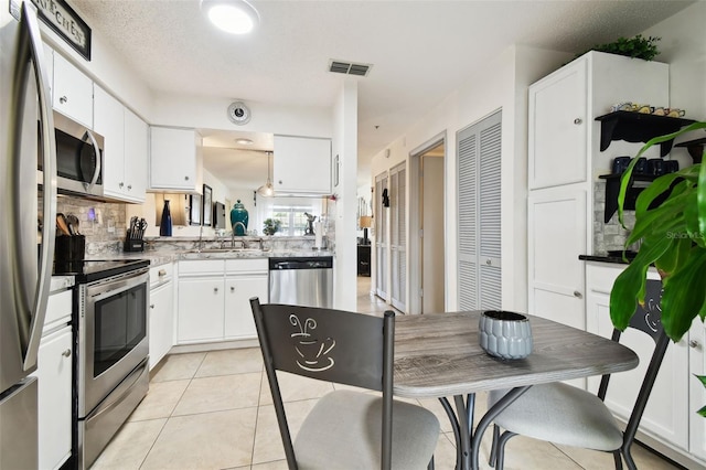 6630 Spring Flower Dr Unit 14, New Port Richey, FL 34653 - kitchen with appliances with stainless steel finishes, white cabinets, decorative backsplash, and a sink