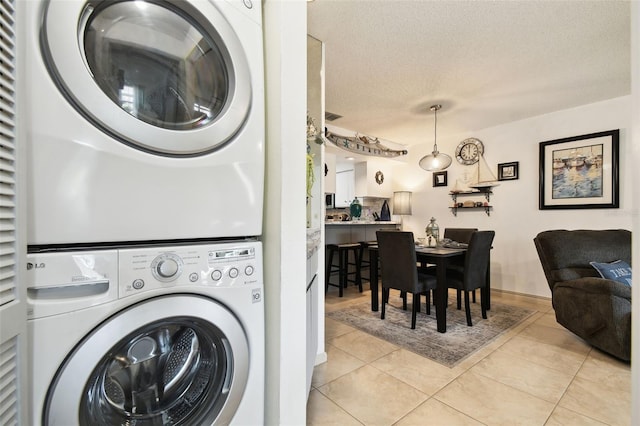 6630 Spring Flower Dr Unit 14, New Port Richey, FL 34653 - laundry room featuring estacked washer and dryer, a textured ceiling, and light tile patterned floors