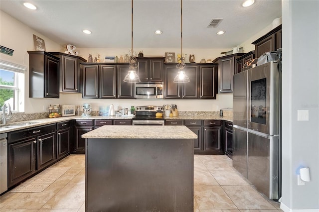 12316 Streambed Dr, Riverview, FL 33579 - kitchen with stainless steel appliances, a sink, a center island, light stone counters, and decorative light fixtures