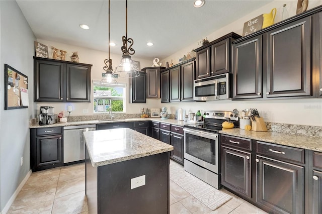 12316 Streambed Dr, Riverview, FL 33579 - kitchen featuring appliances with stainless steel finishes, a kitchen island, a sink, decorative light fixtures, and light stone counters