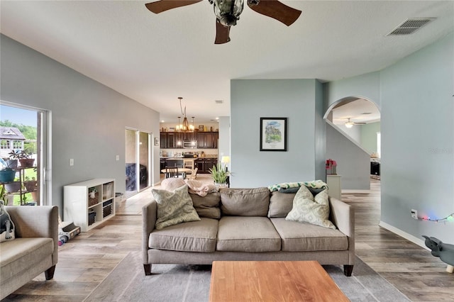 12316 Streambed Dr, Riverview, FL 33579 - living area with a ceiling fan, a chandelier, light wood-style flooring, and arched walkways
