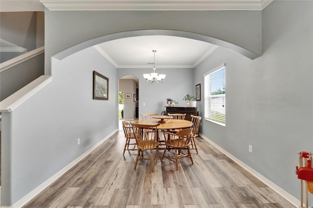 12316 Streambed Dr, Riverview, FL 33579 - dining room with arched walkways, wood finished floors, ornamental molding, baseboards, and a chandelier