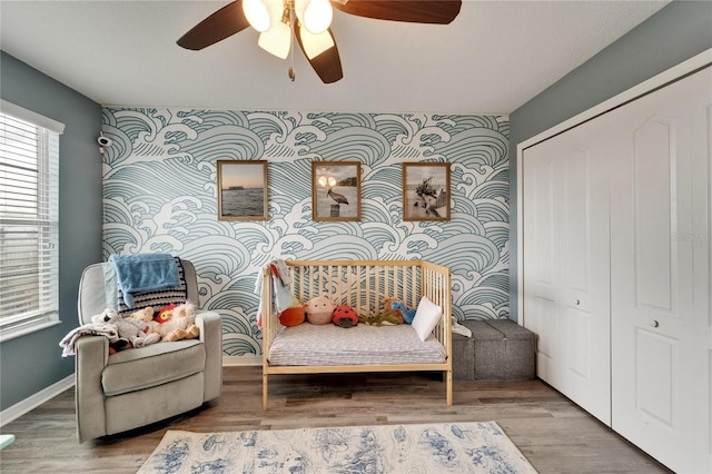 12316 Streambed Dr, Riverview, FL 33579 - sitting room with an accent wall, a ceiling fan, baseboards, wood finished floors, and wallpapered walls