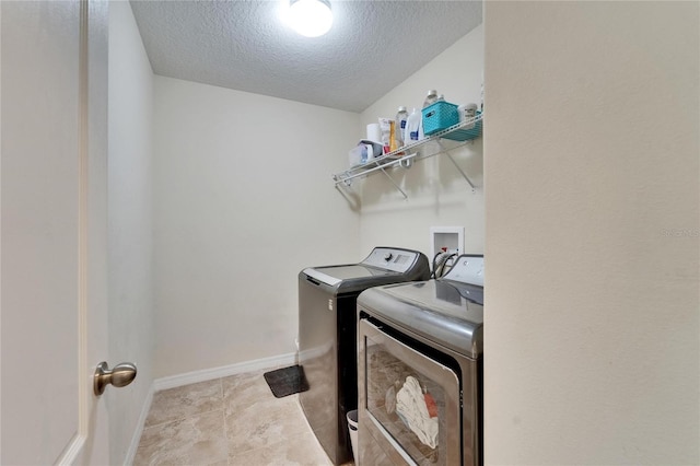 12316 Streambed Dr, Riverview, FL 33579 - washroom with washing machine and clothes dryer, a textured ceiling, and baseboards
