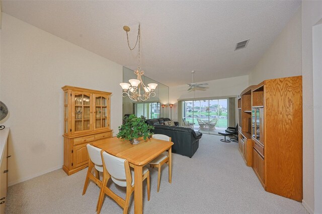 1012 Radison Lake Ct Unit 59, Sun City Center, FL 33573 - dining room with light colored carpet, a chandelier, vaulted ceiling, and a textured ceiling
