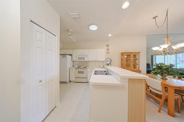 1012 Radison Lake Ct Unit 59, Sun City Center, FL 33573 - kitchen with white appliances, a peninsula, light countertops, ceiling fan, and white cabinetry
