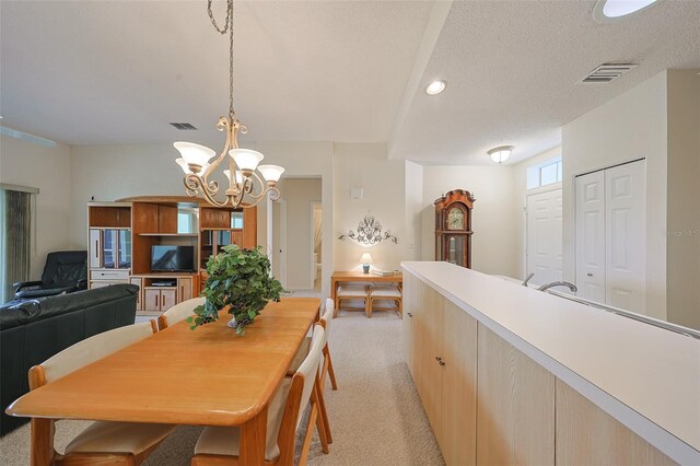 1012 Radison Lake Ct Unit 59, Sun City Center, FL 33573 - dining area featuring light carpet, a chandelier, a textured ceiling, and recessed lighting