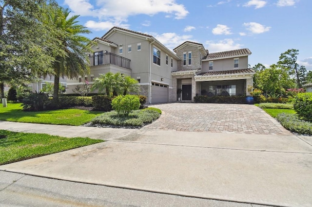 9080 Morgana Ct, Winter Garden, FL 34787 - mediterranean / spanish home with stone siding, decorative driveway, a tile roof, an attached garage, and a balcony