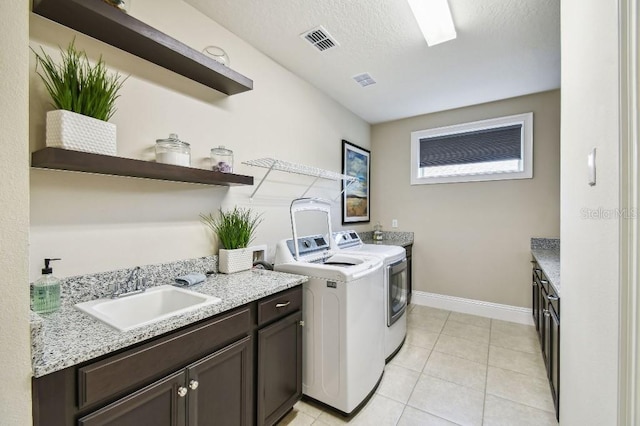 9080 Morgana Ct, Winter Garden, FL 34787 - laundry area with washing machine and dryer, baseboards, light tile patterned floors, a textured ceiling, and cabinet space