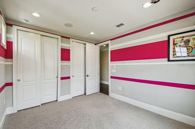 9080 Morgana Ct, Winter Garden, FL 34787 - unfurnished bedroom with carpet, recessed lighting, multiple closets, and baseboards