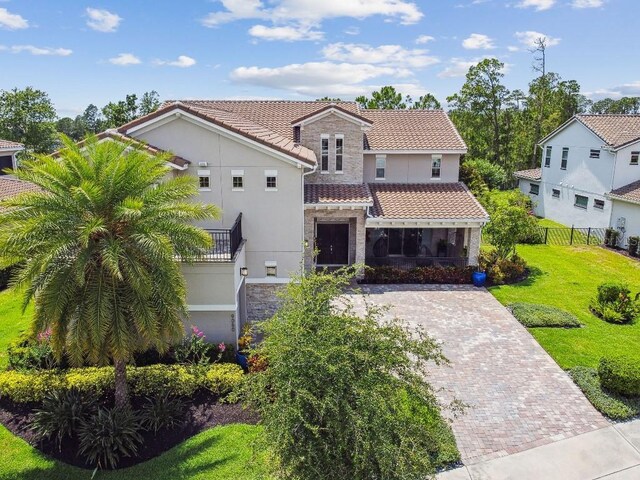 9080 Morgana Ct, Winter Garden, FL 34787 - mediterranean / spanish home featuring stone siding, a tile roof, stucco siding, and decorative driveway