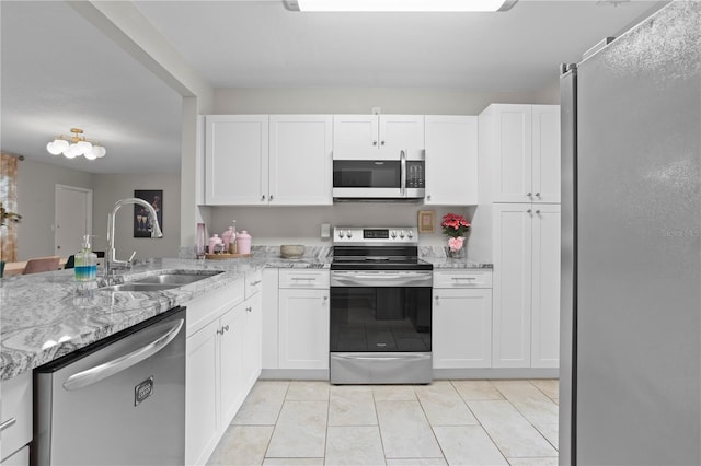 4012 N Munro St, Tampa, FL 33603 - kitchen featuring stainless steel appliances, white cabinetry, light tile patterned floors, and light stone counters