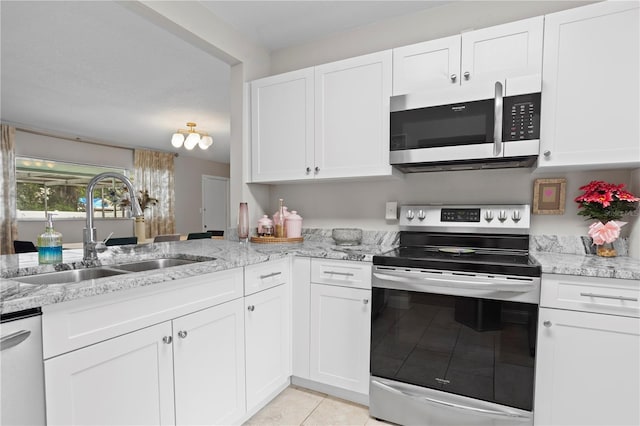 4012 N Munro St, Tampa, FL 33603 - kitchen with stainless steel appliances, light tile patterned flooring, white cabinets, and light stone countertops
