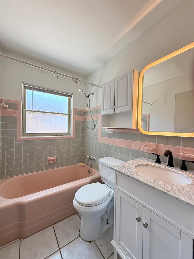 412 73rd Ave, St Pete Beach, FL 33706 - bathroom featuring tile patterned floors, vanity, toilet, shower / bathtub combination, and tile walls