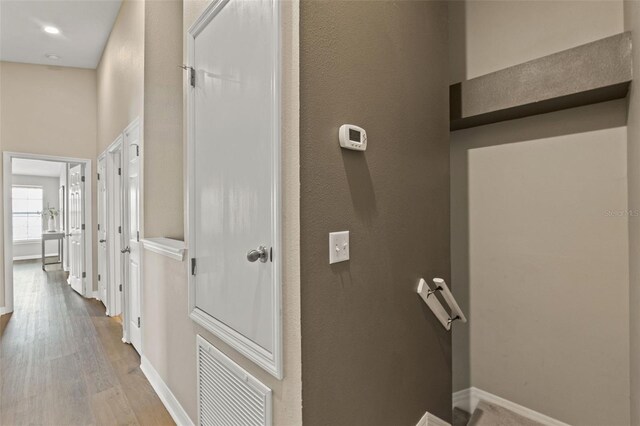 589 52nd Ave N, Saint Petersburg, FL 33703 - corridor with wood finished floors, baseboards, a high ceiling, and an upstairs landing