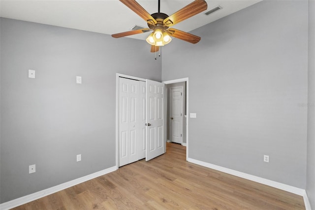 589 52nd Ave N, Saint Petersburg, FL 33703 - unfurnished bedroom featuring baseboards, wood finished floors, a towering ceiling, a closet, and ceiling fan