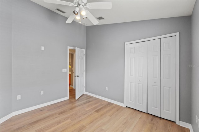 589 52nd Ave N, Saint Petersburg, FL 33703 - unfurnished bedroom with light wood-type flooring, baseboards, a closet, ceiling fan, and a towering ceiling