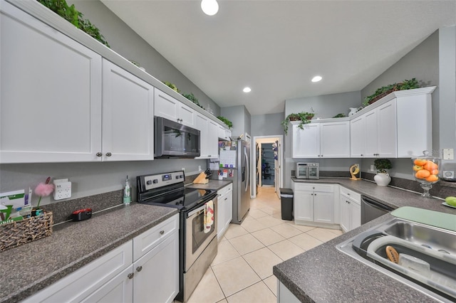 11806 Holly Crest Ln, Riverview, FL 33569 - kitchen featuring stainless steel appliances, white cabinetry, dark countertops, light tile patterned flooring, and recessed lighting