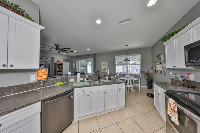 11806 Holly Crest Ln, Riverview, FL 33569 - kitchen featuring appliances with stainless steel finishes, dark countertops, white cabinetry, light tile patterned floors, and a sink