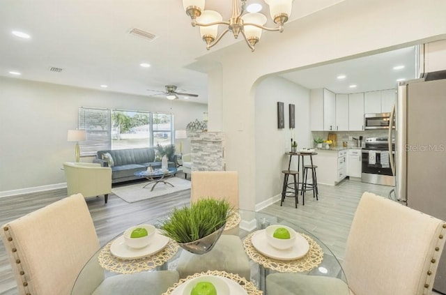 3118 Adrian Ave, Largo, FL 33774 - dining area featuring light wood finished floors, baseboards, a chandelier, arched walkways, and recessed lighting