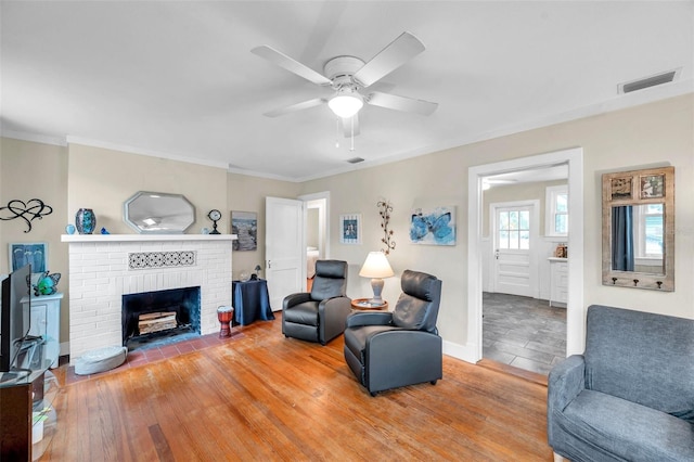 320 Broadway, Dunedin, FL 34698 - living room featuring ceiling fan, ornamental molding, light wood-style floors, a fireplace, and baseboards