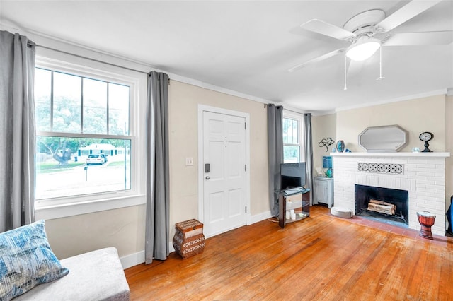 320 Broadway, Dunedin, FL 34698 - living room with baseboards, ceiling fan, a fireplace, light wood finished floors, and crown molding