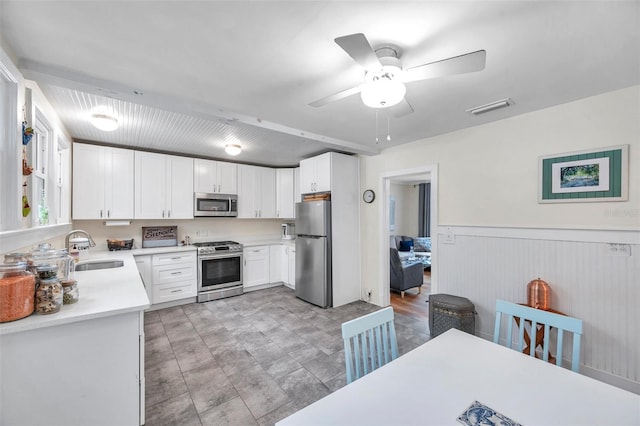 320 Broadway, Dunedin, FL 34698 - kitchen featuring appliances with stainless steel finishes, a sink, light countertops, white cabinets, and a ceiling fan