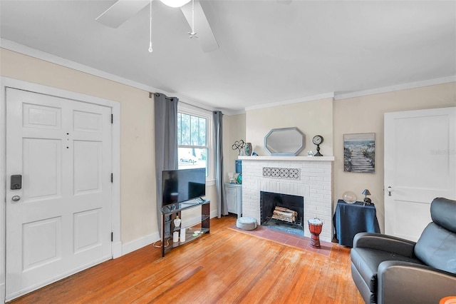 320 Broadway, Dunedin, FL 34698 - living room featuring light wood-type flooring, a brick fireplace, baseboards, ceiling fan, and crown molding