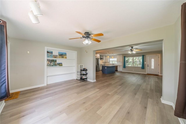 117 Connie Ave, Tampa, FL 33613 - unfurnished living room featuring a ceiling fan, light wood-style flooring, and baseboards