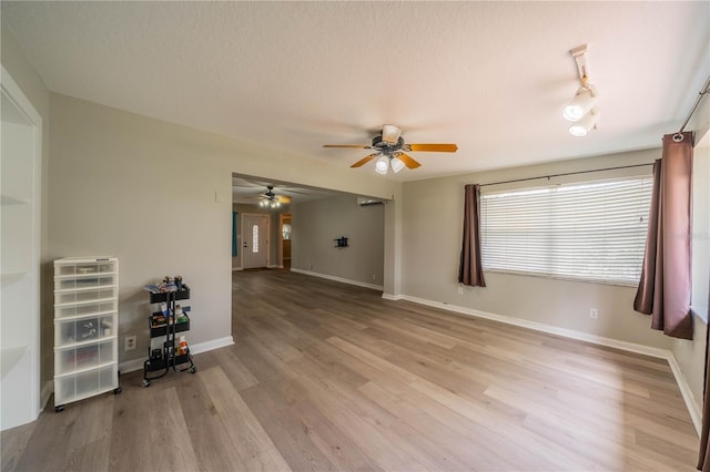 117 Connie Ave, Tampa, FL 33613 - unfurnished living room with a ceiling fan, light wood-style flooring, baseboards, and a textured ceiling