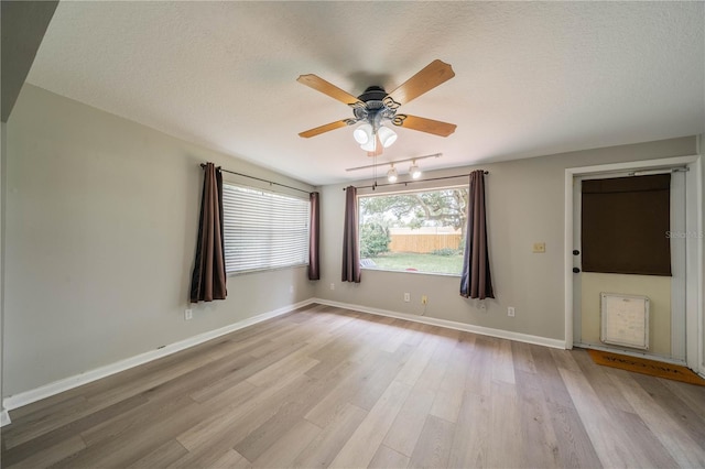 117 Connie Ave, Tampa, FL 33613 - empty room with light wood-style flooring, a ceiling fan, a textured ceiling, and baseboards
