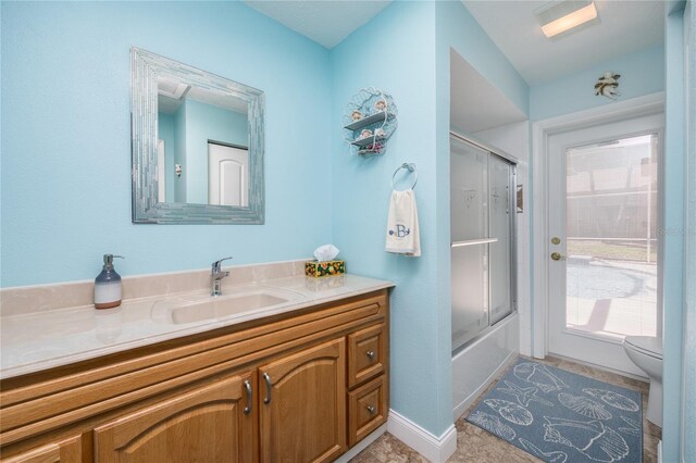 460 Meravan Dr, Palm Harbor, FL 34683 - bathroom featuring vanity, toilet, combined bath / shower with glass door, tile patterned floors, and baseboards