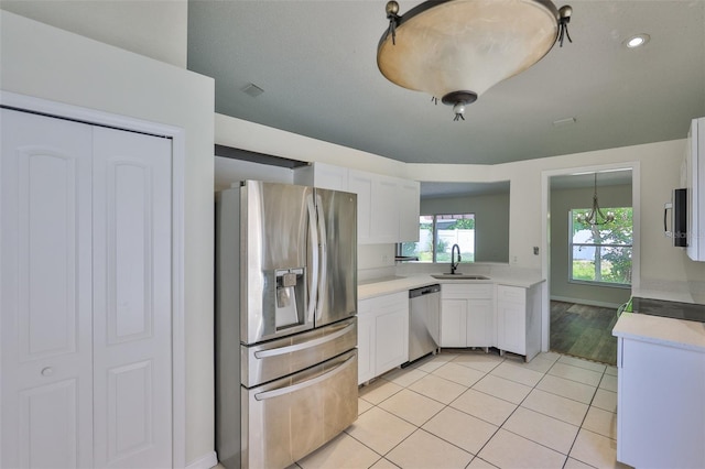 10414 Hallmark Blvd, Riverview, FL 33578 - kitchen with appliances with stainless steel finishes, a sink, light countertops, white cabinets, and light tile patterned floors