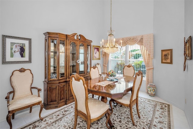 184 Hunter Ct, Palm Harbor, FL 34684 - dining space featuring a towering ceiling, a chandelier, light tile patterned floors, and baseboards