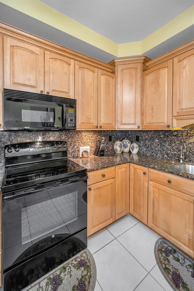 184 Hunter Ct, Palm Harbor, FL 34684 - kitchen featuring black appliances, a sink, dark stone countertops, and light tile patterned floors