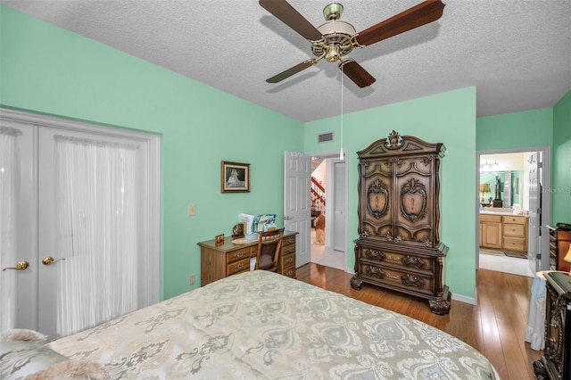 184 Hunter Ct, Palm Harbor, FL 34684 - bedroom with wood finished floors, ensuite bathroom, ceiling fan, and a textured ceiling