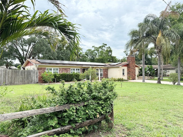 2523 Krueger Ln, Tampa, FL 33618 - view of front of property with roof mounted solar panels, a chimney, and brick siding