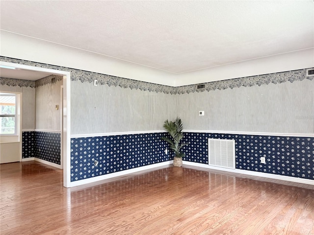 2523 Krueger Ln, Tampa, FL 33618 - spare room with baseboards, wood finished floors, and wallpapered walls