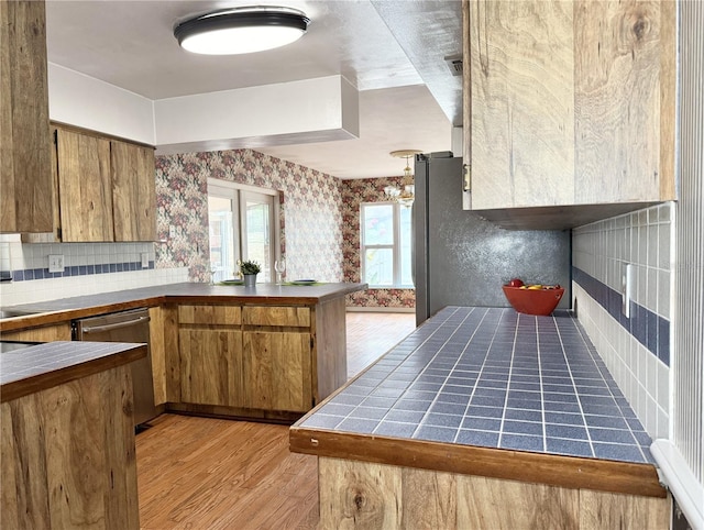 2523 Krueger Ln, Tampa, FL 33618 - kitchen featuring tile countertops, wallpapered walls, stainless steel dishwasher, light wood-style floors, and brown cabinetry