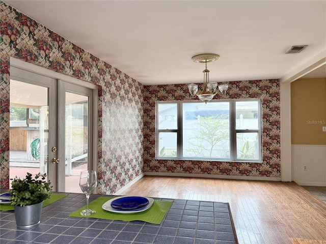 2523 Krueger Ln, Tampa, FL 33618 - unfurnished dining area with wallpapered walls, hardwood / wood-style floors, a chandelier, and baseboards