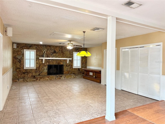 2523 Krueger Ln, Tampa, FL 33618 - living room with a ceiling fan, healthy amount of natural light, wainscoting, a textured ceiling, and a fireplace