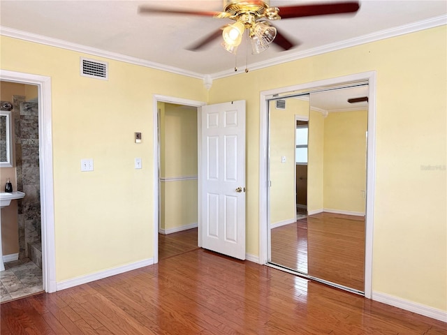 2523 Krueger Ln, Tampa, FL 33618 - unfurnished bedroom featuring wood finished floors, crown molding, ceiling fan, ensuite bathroom, and baseboards