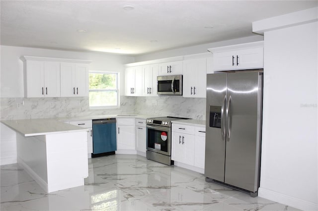 1109 N Obrien St, Tampa, FL 33607 - kitchen featuring stainless steel appliances, a peninsula, light marble finish flooring, and white cabinetry